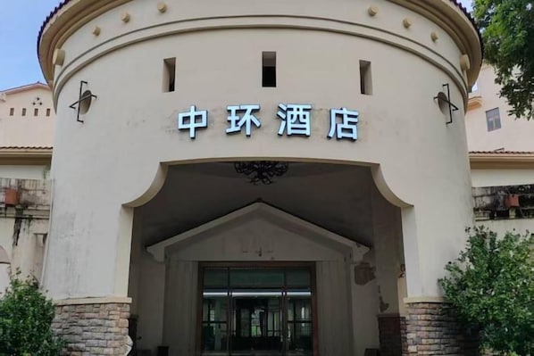 Un edificio con un letrero que dice '中环酒店' (Zhong Huan Hotel).