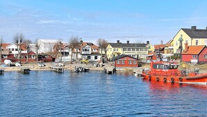 A harbor with boats, a red boat named "PILOT", and buildings including a yellow one with "SANDHAMNS VARDSHUS" sign. - 5 Star Holiday Home in Haro (Harö)