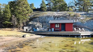 A small red building with a tiled roof, surrounded by a rocky landscape and trees. - 5 Star Holiday Home in Haro (Harö)