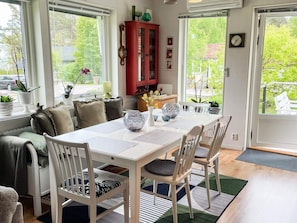 A dining area with a white table, chairs, and a red cabinet. - 5 Person Holiday Home in 38472 (Timmernabben)