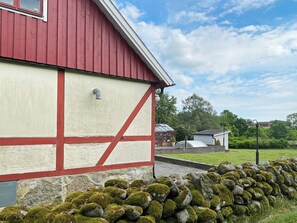 Un edificio rojo y blanco con un muro de piedra en primer plano.