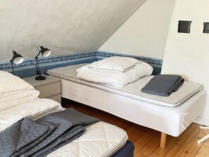A bedroom with a single bed, a nightstand, two bedside lamps, and a blue decorative border on the wall. - 4 Person Holiday Home in Lovestad (Lövestad)