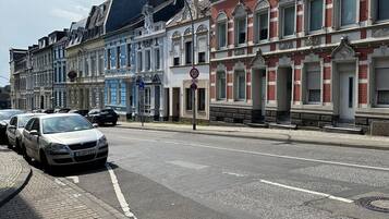 A street with historic buildings, a speed limit sign, and parked cars.