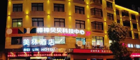Ein mehrgeschossiges Hotel mit beleuchteter Beschilderung, inklusive Hotelname und Businesscenter.