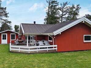 A red building with a covered patio area and outdoor seating. - 6 Person Holiday Home in Otterup (Otterup)