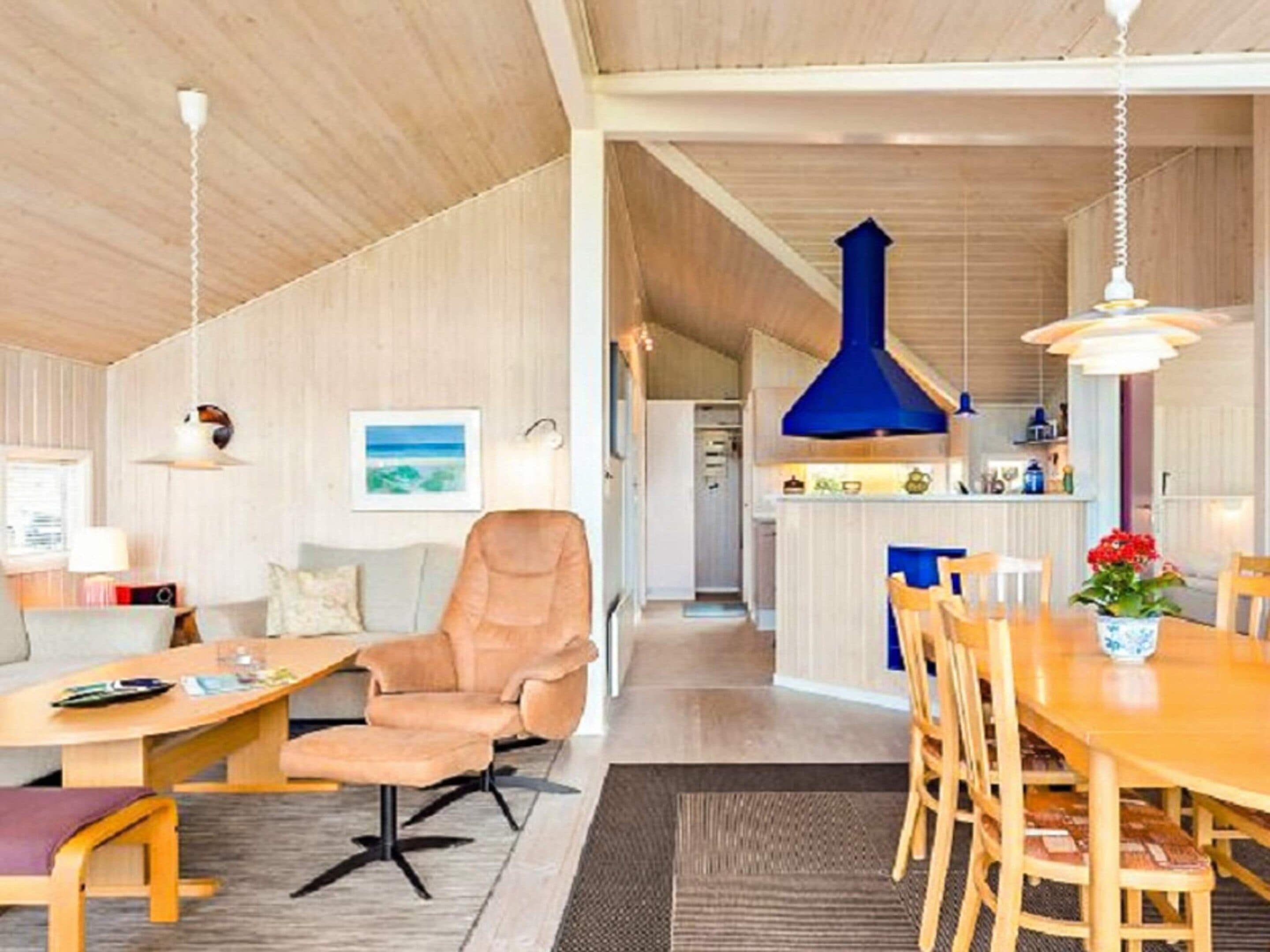 Un intérieur moderne avec un coin repas, un canapé et une cuisine en arrière-plan.