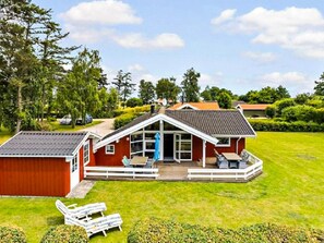 A red house with a white porch and a covered patio area. - 6 Person Holiday Home in Otterup (Otterup)