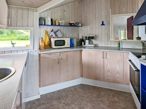 A kitchen with wooden cabinets, a microwave, and a coffee maker. - 6 Person Holiday Home in Otterup (Otterup)