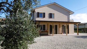 Une maison à deux étages dotée d’un patio couvert.