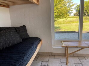 A room with a bed, a window, and a view of a grassy field. - Light-filled Retreat in Boddum (Hurup Thy)