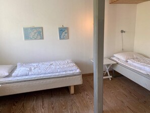 A room with two single beds, a wooden floor, and two wall-mounted maps. - Light-filled Retreat in Boddum (Hurup Thy)