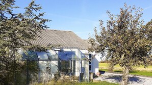 A greenhouse with a metal frame and glass panels, surrounded by grass and trees. - 4 Person Holiday Home in Hurup Thy (Hurup Thy)