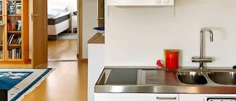 A compact kitchen with a built-in oven, a sink, and a small countertop.