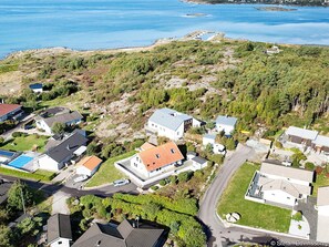An aerial view of a residential area with houses, a swimming pool, and a road. - 4 Star Holiday Home in Frillesas (Frillesas)