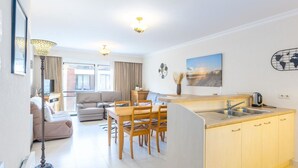 A modern apartment with a dining area, kitchen, and living room. - Apartment in Middelkerke Near Sandy Beach (Middelkerke)
