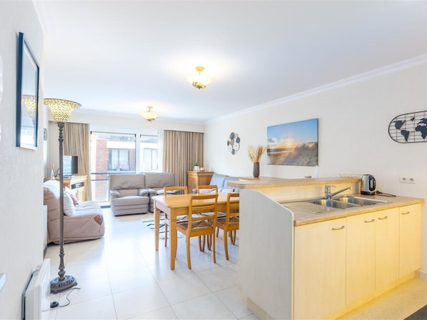 Een modern appartement met een eethoek, keuken en woonkamer.