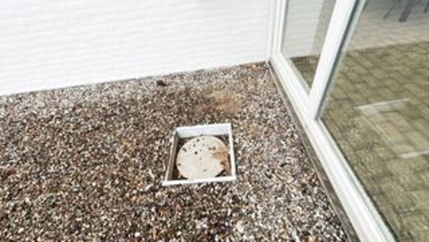A gravel-covered ground with a white drain cover. - 8 Person Holiday Home in Romo (Rømø)