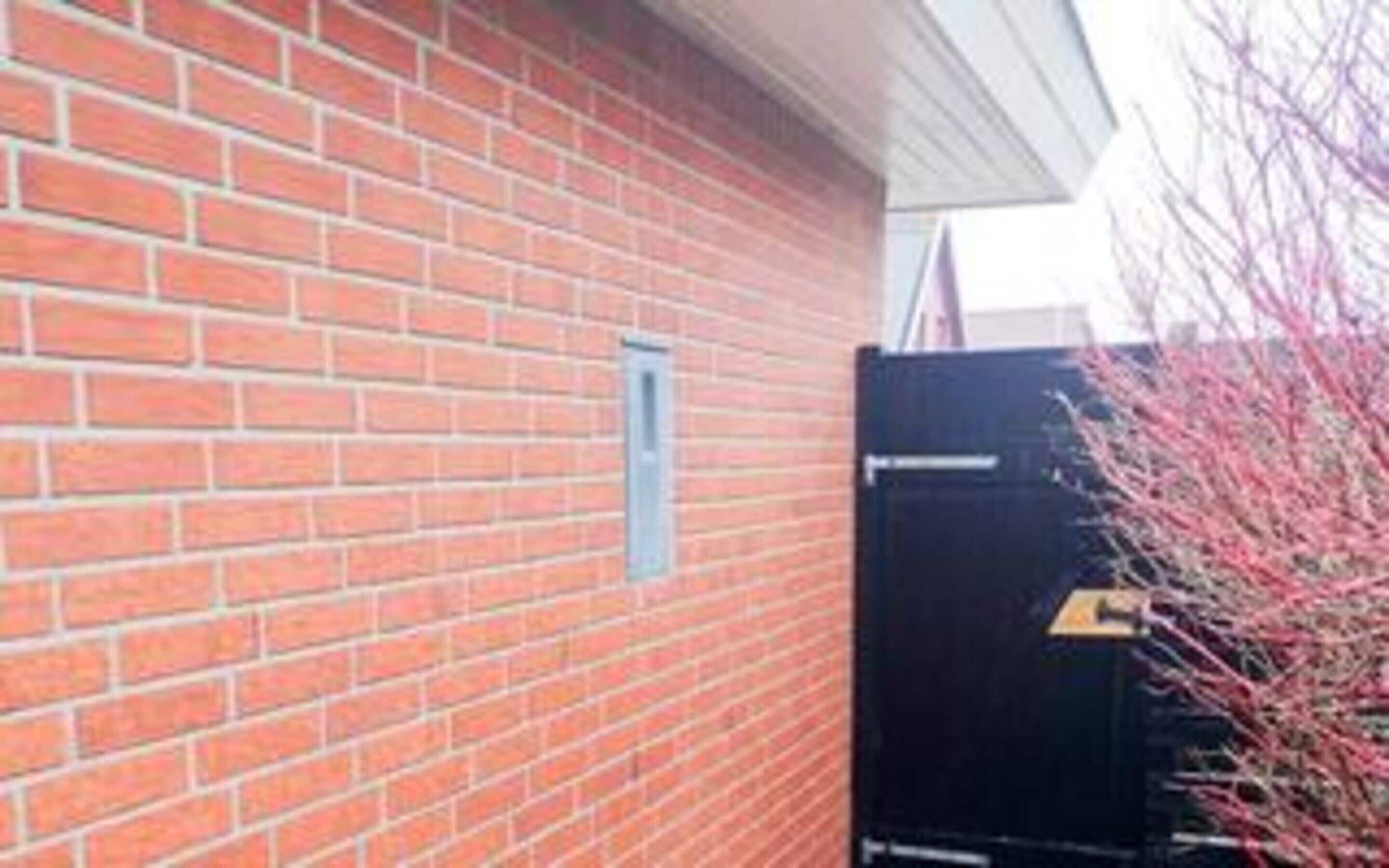 A brick building with a door and a small window.