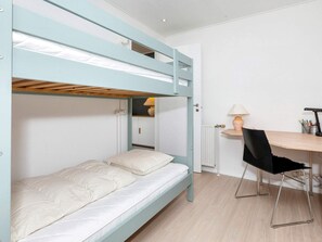 A bunk bed with a desk and chair, a lamp, and a radiator. - 4 Star Holiday Home in Blokhus (Blokhus)