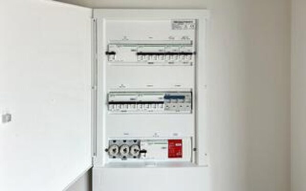 Un panneau de distribution électrique équipé de plusieurs disjoncteurs et interrupteurs.