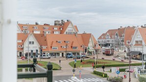 A town square with traditional European architecture, a pedestrian crossing, and a clear sky. - Stylish Apartment With Balcony/terrace (De Haan)