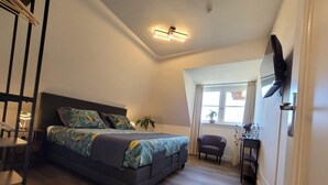 A modern bedroom with a bed, a desk, a chair, and a window. - Villa in Overloon Near War Museum (Overloon)