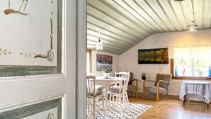 An interior with a dining area featuring a table and chairs, a window with plants, and a ceiling fan. - 4 Person Holiday Home in Kolmarden (Kolmården)