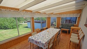 A covered patio with a dining table and chairs, a sofa, and a small table. - 6 Person Holiday Home in Skummeslovsstrand (Skummesloevsstrand)