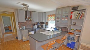 A compact kitchen with a central island, built-in cabinets, and a small dining area with two chairs. - 6 Person Holiday Home in Skummeslovsstrand (Skummesloevsstrand)