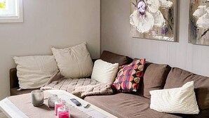 Un salon avec un canapé marron, une table basse et un tableau accroché au mur.