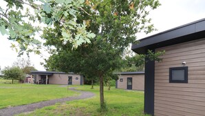 Un bâtiment moderne avec un chemin de gravier menant à un espace extérieur abrité.