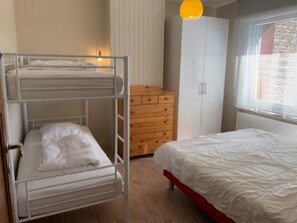 A bunk bed with a wooden dresser and a single bed with a red frame. - Canal-side Family Retreat (Nieuwpoort)