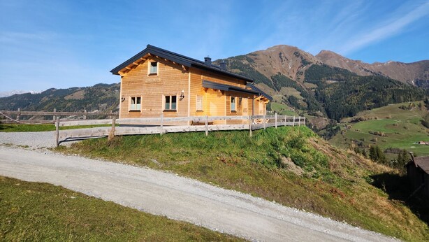 A wooden house with a sloped roof, a wooden porch, and a gravel driveway. - Alpine hut in Rauris ski Hiking Area With Sauna (Rauris)