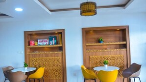 A room with a white ceiling, wooden panel walls, a round table with chairs, and a hanging light fixture. - Lavender Spa and Suites (Enugu)