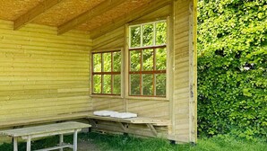 A wooden cabin with a bench and two windows. - 4 Star Holiday Home in Vejby (Vejby)