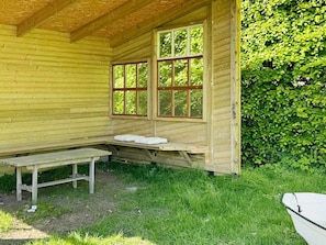 A wooden cabin with a bench and two windows. - 4 Star Holiday Home in Vejby (Vejby)