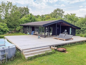 A modern cabin with a deck, outdoor seating, and a barbecue area. - 4 Star Holiday Home in Vejby (Vejby)