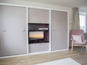 Relax in a stylish room with an entertainment unit, flat-screen TV, and comfortable seating area.