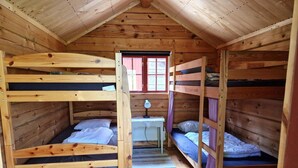 A cabin with bunk beds, a small table, and a window. - 7 Person Holiday Home in Saffle (Saffle)