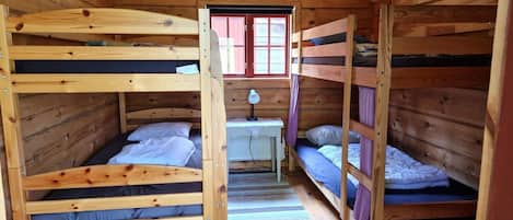 A cabin with bunk beds, a small table, and a window.