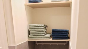 A bathroom with a towel rack and shelves holding folded towels. - Modernized Holiday Home With Terrace (Munstergeleen)