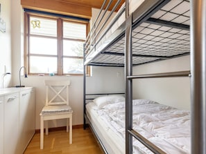 A bunk bed room with a desk and chair, a window with a butterfly sticker, and a wooden ceiling. - 4 Person Holiday Home in Karrebaeksminde (Karrebæksminde)