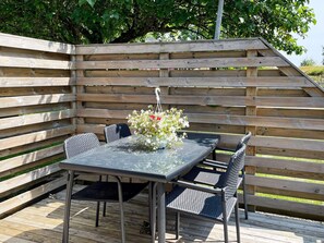 An outdoor patio with a table and chairs, surrounded by wooden slats. - 4 Person Holiday Home in Morrum (Morrum)