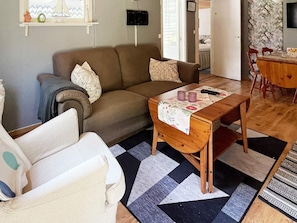 A living room with a sofa, a coffee table, and a dining table. - 4 Person Holiday Home in Morrum (Morrum)