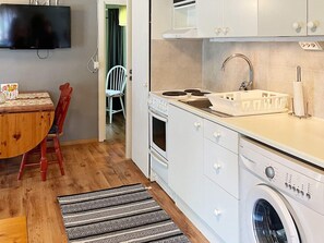 A compact kitchen with a stove, sink, and washing machine. - 4 Person Holiday Home in Morrum (Morrum)