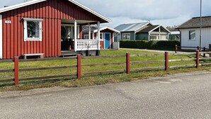 A row of red and white mobile homes with a gravel driveway and wooden fence. - 6 Person Holiday Home in Laholm (Skummesloevsstrand)