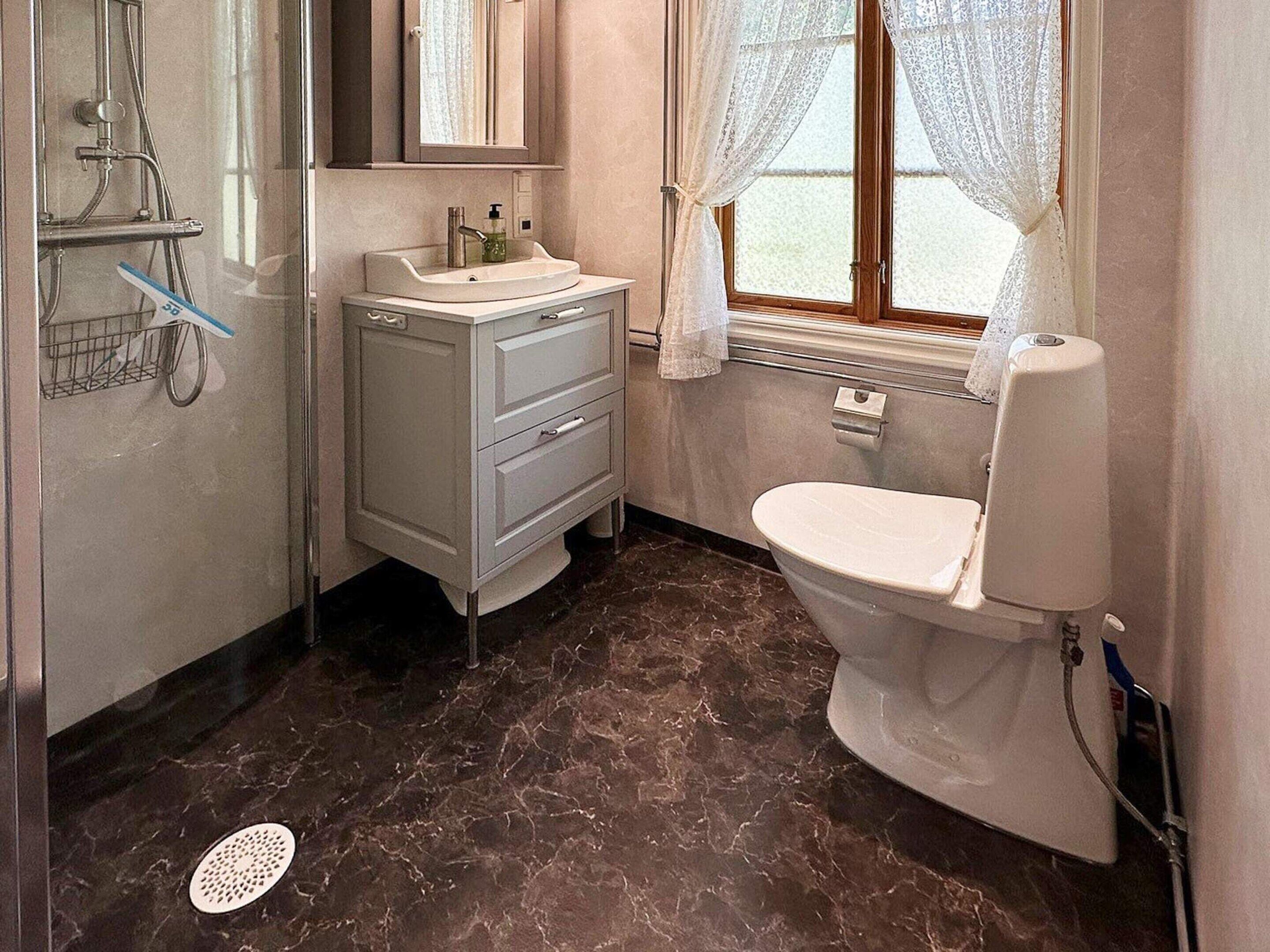 Un baño con inodoro, lavamanos y ducha.