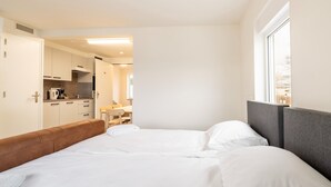 A bedroom with a bed, a wooden headboard, and a window. - Serene Stay With All You Need (Landgraaf)