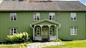 Un bâtiment écologique doté d’un porche, de fenêtres et d’un chemin en pierre.