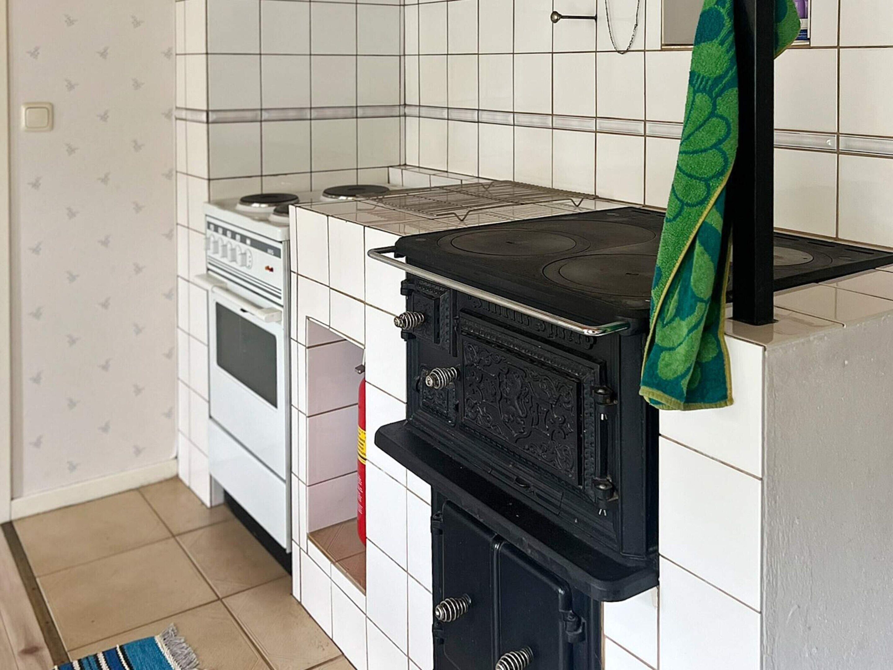 A kitchen with a stove, oven, and a towel hanging on the oven handle.